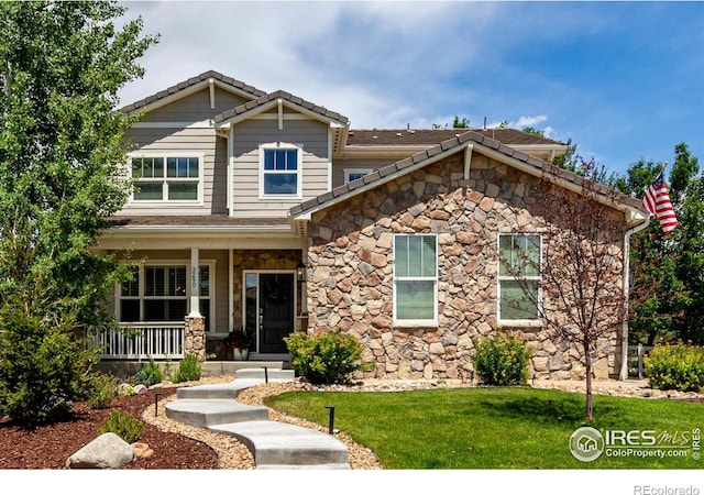 3290 Discovery Ct, Broomfield, CO 80023 - craftsman inspired home featuring stone siding, covered porch, a tiled roof, and a front yard
