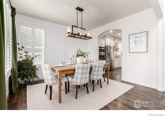 3290 Discovery Ct, Broomfield, CO 80023 - dining space featuring arched walkways, dark wood-style floors, recessed lighting, and a chandelier