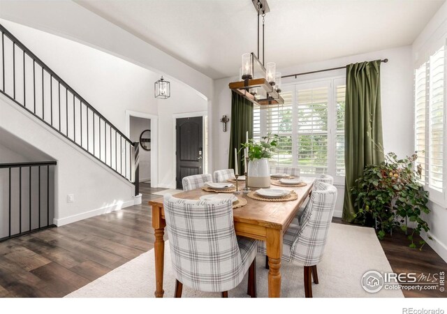 3290 Discovery Ct, Broomfield, CO 80023 - dining area featuring a chandelier, dark wood-type flooring, healthy amount of natural light, and stairway