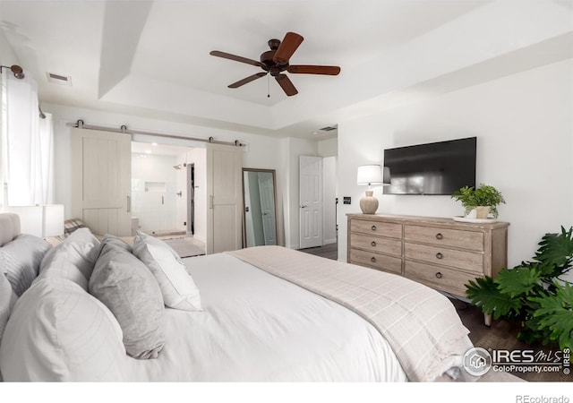 3290 Discovery Ct, Broomfield, CO 80023 - bedroom featuring a barn door, a raised ceiling, dark wood finished floors, and a ceiling fan