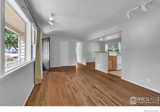 2416 15th Ave, Greeley, CO 80631 - unfurnished living room with rail lighting and light wood finished floors