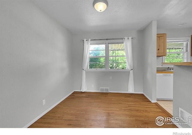 2416 15th Ave, Greeley, CO 80631 - unfurnished dining area with light wood finished floors and a textured ceiling