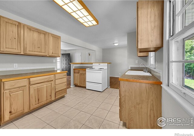 2416 15th Ave, Greeley, CO 80631 - kitchen with white electric range oven, light tile patterned floors, and light brown cabinets