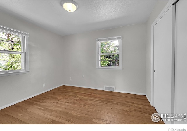 2416 15th Ave, Greeley, CO 80631 - unfurnished bedroom featuring light wood finished floors, a textured ceiling, and a closet