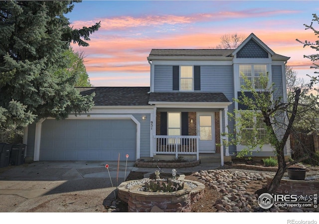 951 Vetch Cir, Lafayette, CO 80026 - traditional home featuring a porch, concrete driveway, an attached garage, and roof with shingles