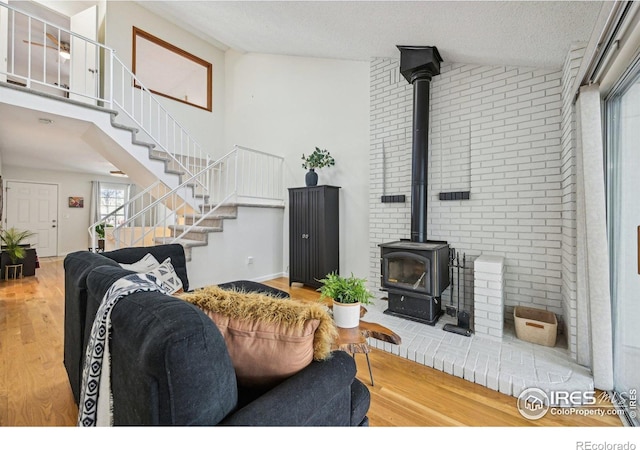 951 Vetch Cir, Lafayette, CO 80026 - living area with a wood stove, wood finished floors, stairway, and a textured ceiling