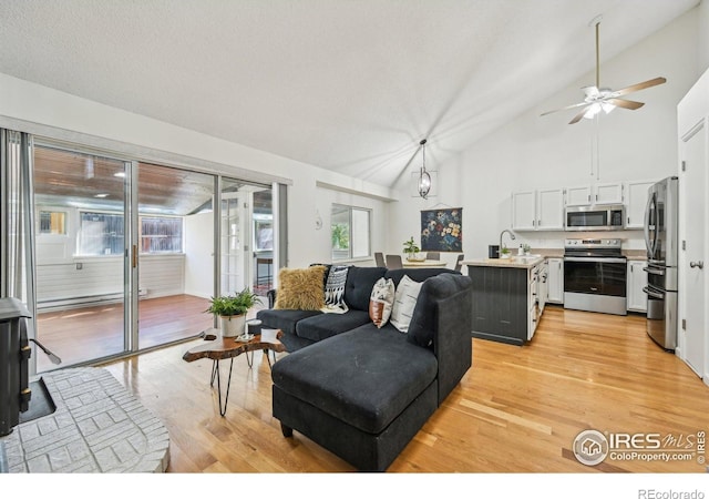 951 Vetch Cir, Lafayette, CO 80026 - living room with light wood-style flooring, a ceiling fan, and high vaulted ceiling