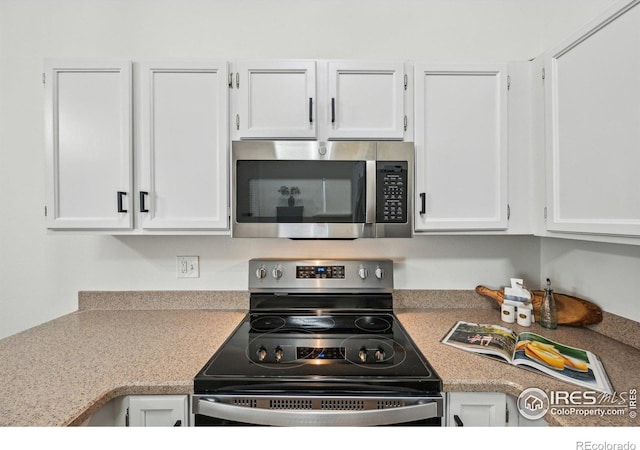 951 Vetch Cir, Lafayette, CO 80026 - kitchen with appliances with stainless steel finishes, white cabinetry, and light countertops
