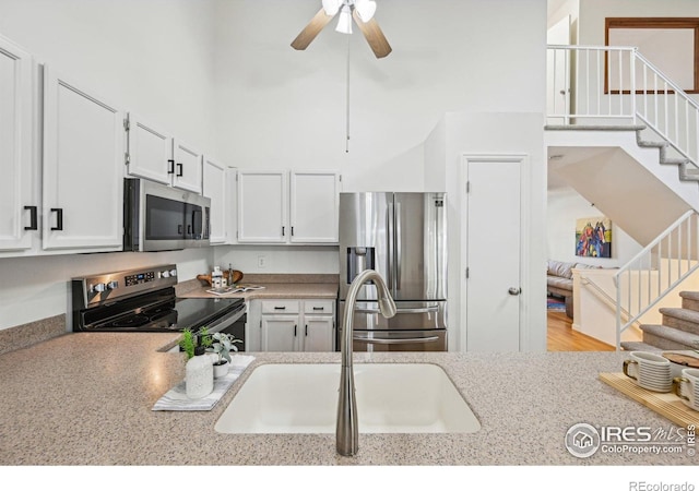 951 Vetch Cir, Lafayette, CO 80026 - kitchen featuring appliances with stainless steel finishes, a ceiling fan, white cabinetry, a high ceiling, and light countertops