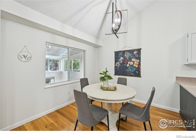 951 Vetch Cir, Lafayette, CO 80026 - dining space with light wood finished floors, vaulted ceiling, and a textured ceiling