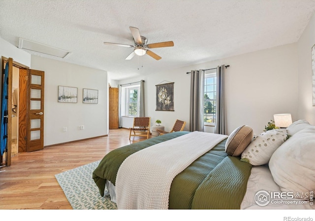 951 Vetch Cir, Lafayette, CO 80026 - bedroom featuring attic access, light wood-type flooring, a textured ceiling, and ceiling fan
