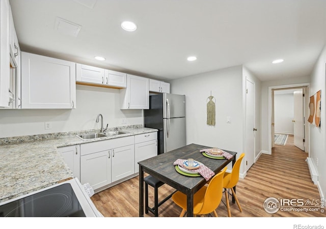 951 Vetch Cir, Lafayette, CO 80026 - kitchen featuring freestanding refrigerator, white electric range, baseboard heating, light wood finished floors, and recessed lighting