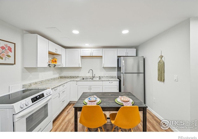 951 Vetch Cir, Lafayette, CO 80026 - kitchen with white electric range oven, freestanding refrigerator, light wood-type flooring, white cabinets, and recessed lighting
