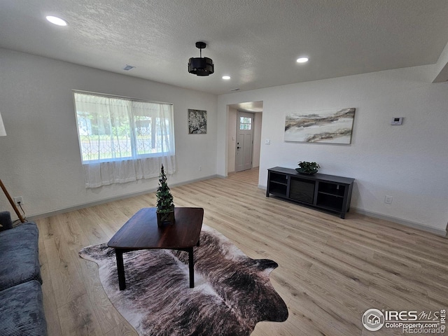 202 N 7th Ave, Sterling, CO 80751 - living room featuring wood finished floors, recessed lighting, and a textured ceiling