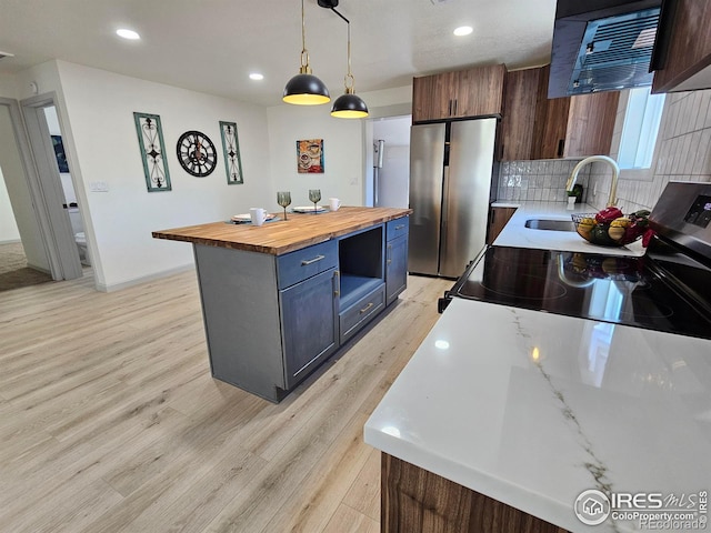 202 N 7th Ave, Sterling, CO 80751 - kitchen with wooden counters, stainless steel appliances, light wood-type flooring, recessed lighting, and a kitchen island