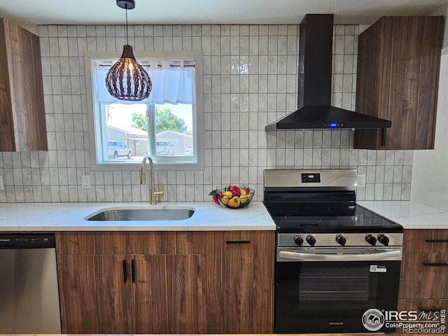 202 N 7th Ave, Sterling, CO 80751 - kitchen with stainless steel appliances, wall chimney exhaust hood, backsplash, brown cabinetry, and modern cabinets