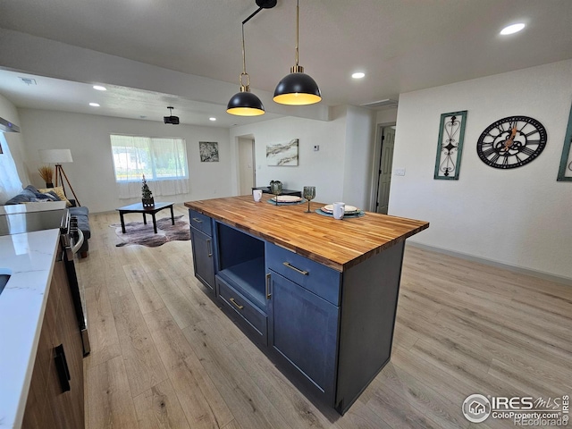 202 N 7th Ave, Sterling, CO 80751 - kitchen featuring wood counters, light wood-type flooring, recessed lighting, hanging light fixtures, and a kitchen island