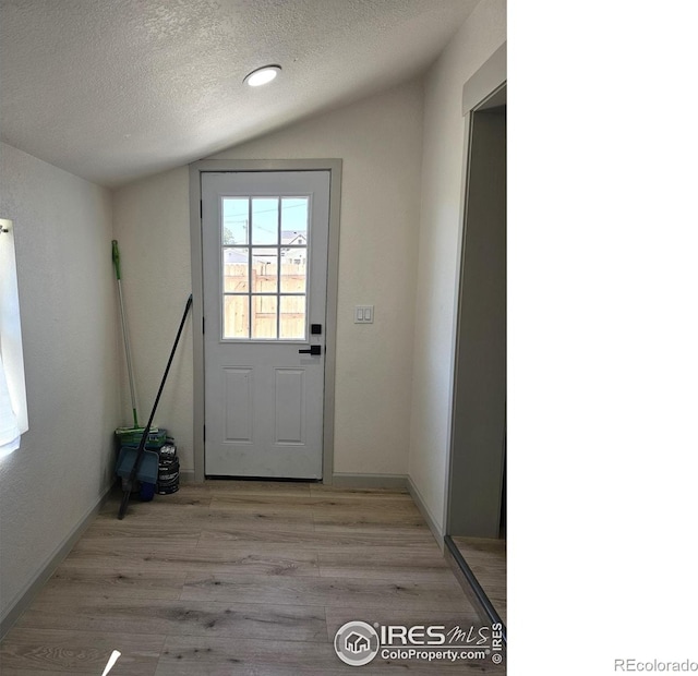 202 N 7th Ave, Sterling, CO 80751 - doorway to outside featuring a textured ceiling, vaulted ceiling, light wood-type flooring, and recessed lighting