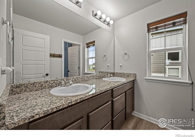 12648 Canoe St, Firestone, CO 80504 - full bath with double vanity, wood finished floors, and a textured wall