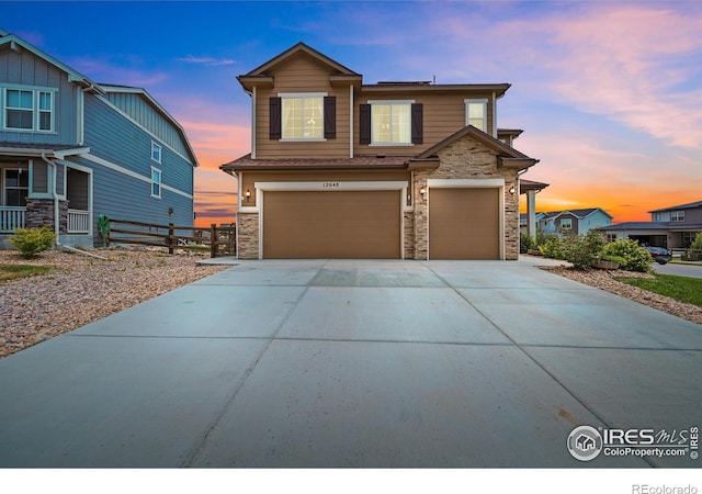 12648 Canoe St, Firestone, CO 80504 - view of front of house with stone siding, a garage, and driveway