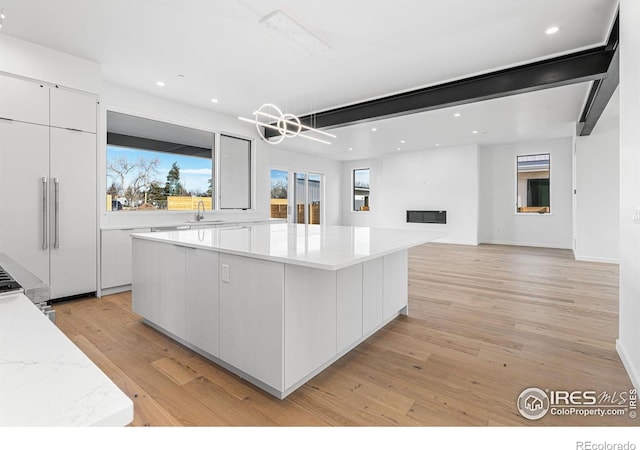 2145 Vine Ave, Boulder, CO 80304 - kitchen with modern cabinets, white cabinetry, a large island, recessed lighting, and light wood-type flooring
