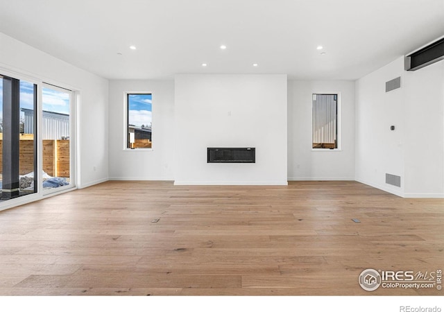 2145 Vine Ave, Boulder, CO 80304 - unfurnished living room featuring a glass covered fireplace, recessed lighting, and light wood-type flooring