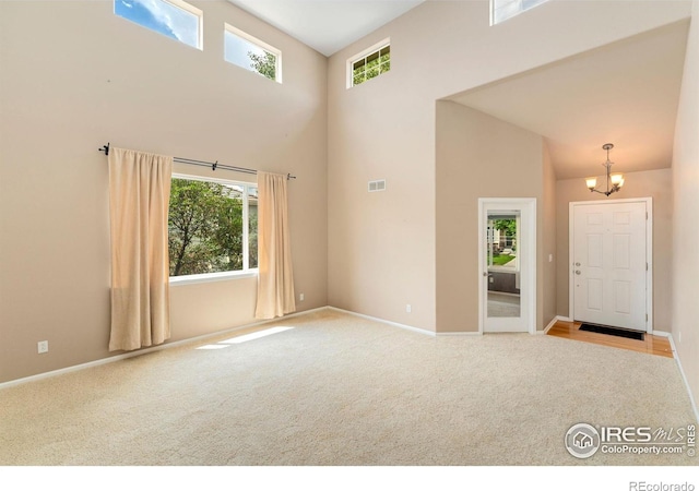17132 E 104th Way, Commerce City, CO 80022 - carpeted empty room featuring a high ceiling, plenty of natural light, and a chandelier
