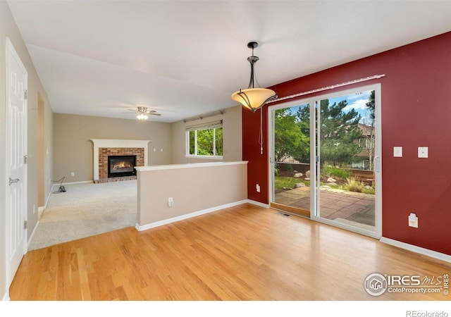 17132 E 104th Way, Commerce City, CO 80022 - unfurnished dining area featuring light wood-style flooring, a brick fireplace, and ceiling fan