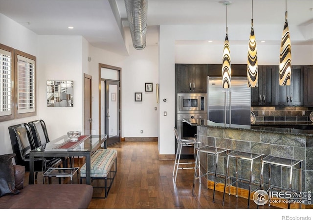 820 Pearl St, Boulder, CO 80302 - kitchen featuring built in appliances, dark wood-style flooring, dark brown cabinetry, a breakfast bar, and recessed lighting