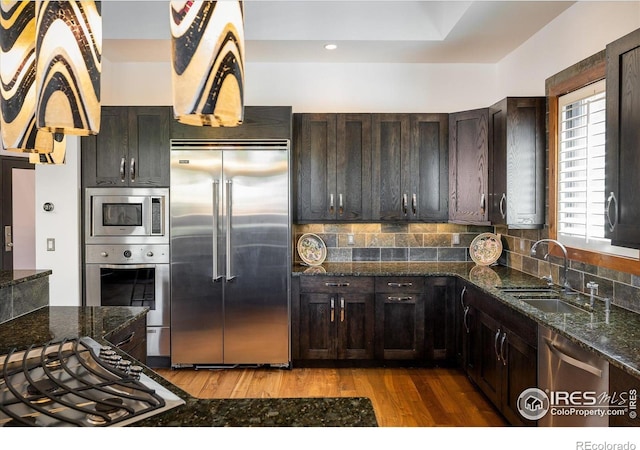 820 Pearl St, Boulder, CO 80302 - kitchen featuring built in appliances, wood finished floors, dark stone countertops, backsplash, and dark brown cabinets
