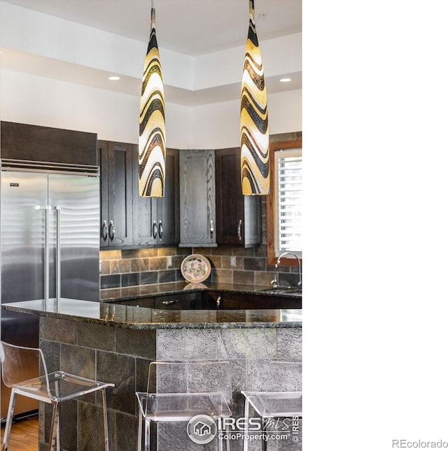 820 Pearl St, Boulder, CO 80302 - kitchen with a breakfast bar area, built in fridge, tasteful backsplash, and dark stone counters
