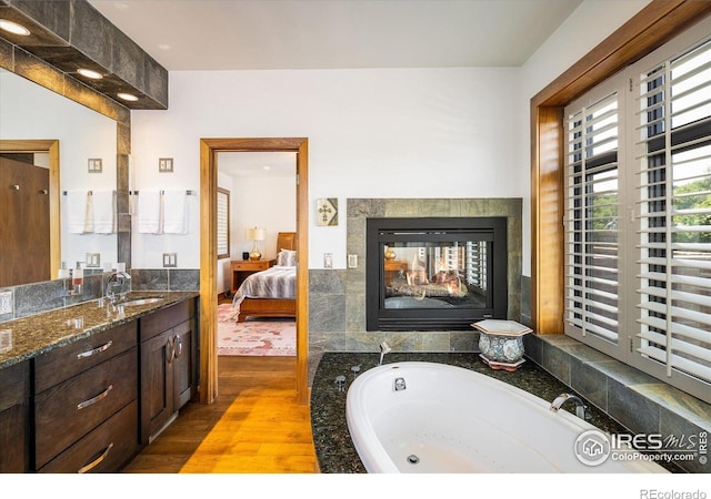 820 Pearl St, Boulder, CO 80302 - ensuite bathroom with wood finished floors, vanity, a bath, and a multi sided fireplace