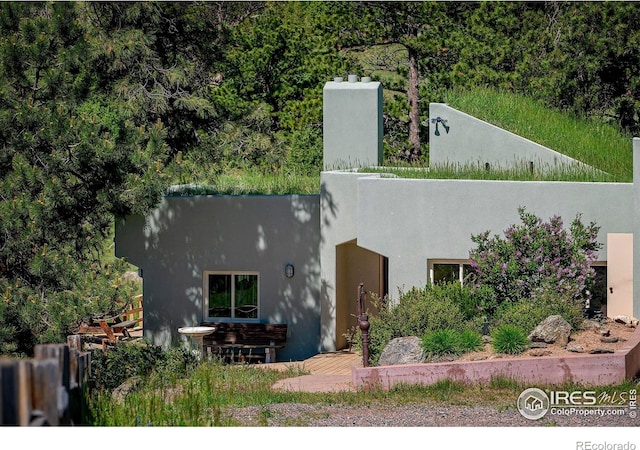 3884 Douglas Mountain Dr, Golden, CO 80403 - view of front of house with stucco siding and a chimney