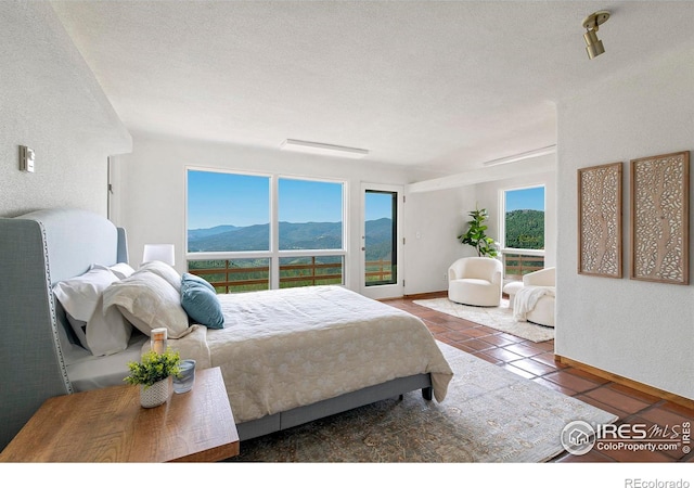 3884 Douglas Mountain Dr, Golden, CO 80403 - bedroom featuring a mountain view, tile patterned flooring, and a textured ceiling