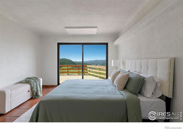 3884 Douglas Mountain Dr, Golden, CO 80403 - tiled bedroom featuring access to outside, a textured ceiling, and a textured wall