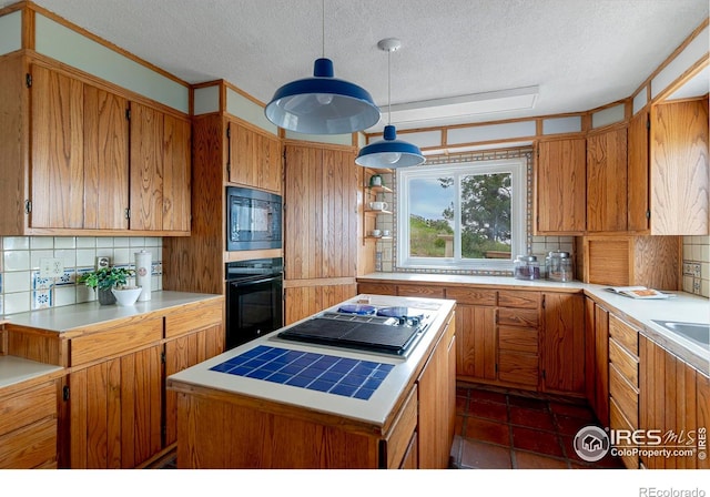 3884 Douglas Mountain Dr, Golden, CO 80403 - kitchen featuring black appliances, backsplash, a textured ceiling, a center island, and light countertops