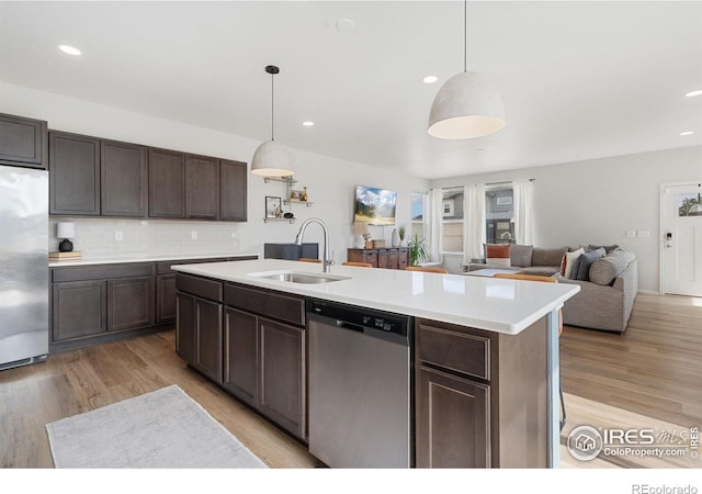 5199 Beckworth St, Timnath, CO 80547 - kitchen with appliances with stainless steel finishes, dark brown cabinetry, light countertops, light wood-style flooring, and backsplash
