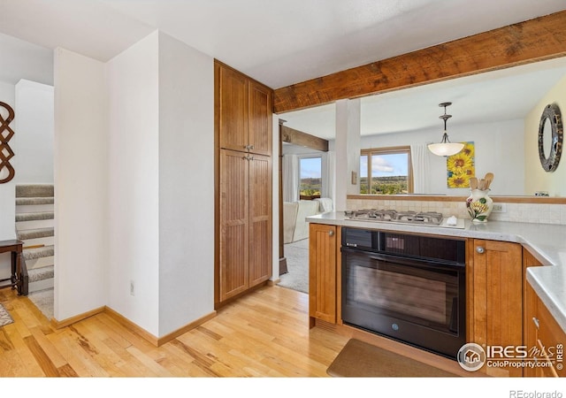1620 Bradley Ct, Boulder, CO 80305 - kitchen with oven, stainless steel gas stovetop, light wood-style flooring, and brown cabinetry