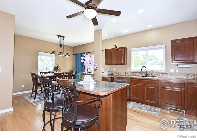 405 Ridgeview Ct, Johnstown, CO 80534 - kitchen featuring light wood finished floors, a breakfast bar area, healthy amount of natural light, a ceiling fan, and recessed lighting