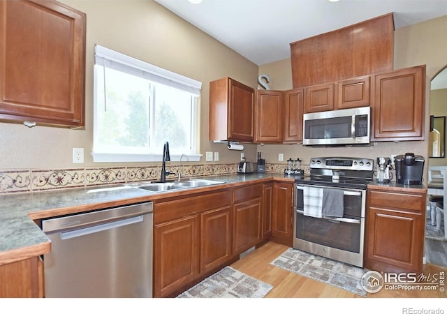 405 Ridgeview Ct, Johnstown, CO 80534 - kitchen with stainless steel appliances, light wood finished floors, and brown cabinets