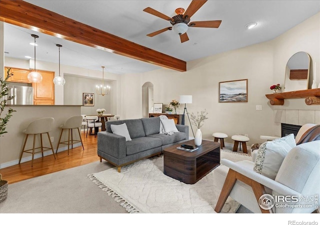 5220 Boardwalk Dr Unit 22, Fort Collins, CO 80525 - living area with a ceiling fan, beamed ceiling, a tiled fireplace, arched walkways, and a chandelier