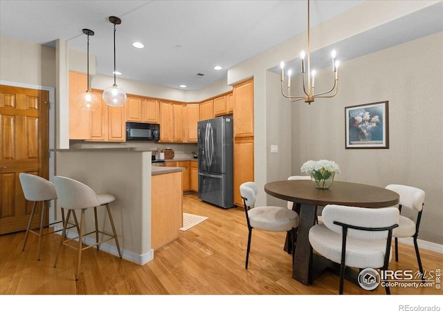 5220 Boardwalk Dr Unit 22, Fort Collins, CO 80525 - kitchen featuring freestanding refrigerator, black microwave, a peninsula, light wood finished floors, and recessed lighting