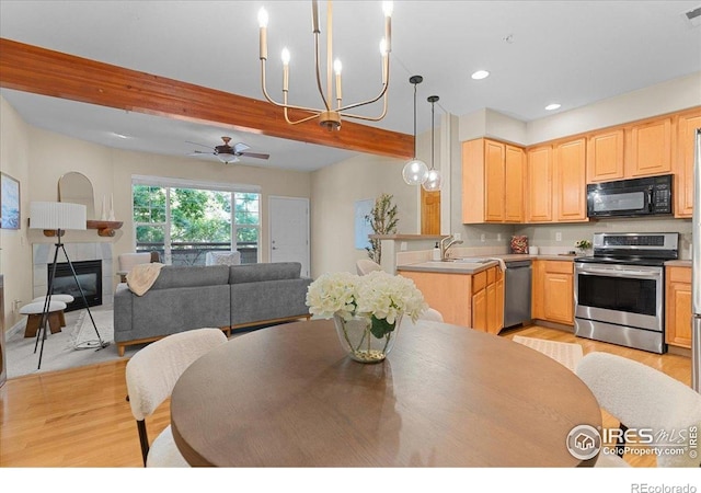 5220 Boardwalk Dr Unit 22, Fort Collins, CO 80525 - kitchen featuring appliances with stainless steel finishes, light brown cabinetry, light wood-style floors, open floor plan, and beam ceiling