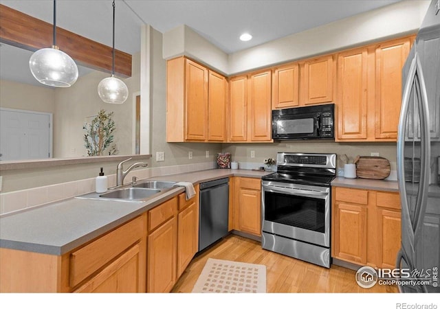 5220 Boardwalk Dr Unit 22, Fort Collins, CO 80525 - kitchen featuring stainless steel appliances, light wood-style flooring, decorative light fixtures, a peninsula, and light countertops