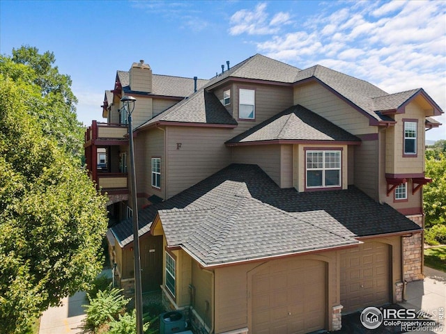 5220 Boardwalk Dr Unit 22, Fort Collins, CO 80525 - view of front of property featuring roof with shingles, a chimney, and a garage