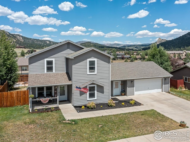 1695 Gray Hawk Ct, Estes Park, CO 80517 - view of front of home with covered porch, a mountain view, an attached garage, and driveway