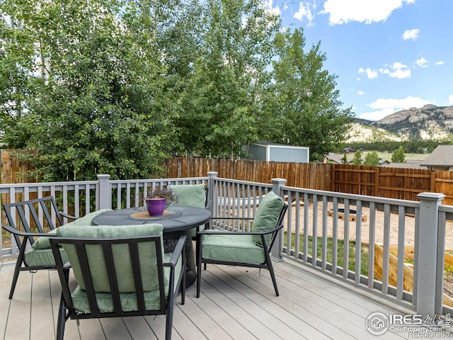 1695 Gray Hawk Ct, Estes Park, CO 80517 - deck with outdoor dining space, a fenced backyard, and a mountain view