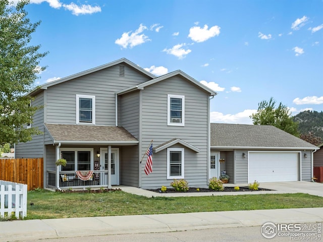 1695 Gray Hawk Ct, Estes Park, CO 80517 - traditional-style house featuring a porch, an attached garage, concrete driveway, and roof with shingles
