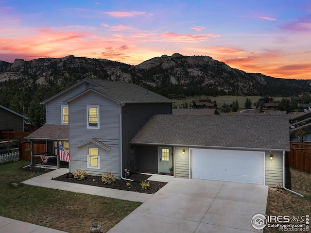 1695 Gray Hawk Ct, Estes Park, CO 80517 - traditional-style house featuring a mountain view, driveway, a garage, a porch, and roof with shingles