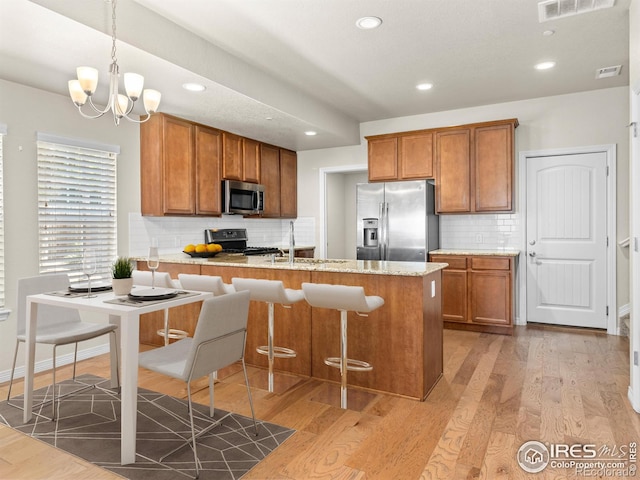 3038 County Fair Ln Unit 1, Fort Collins, CO 80528 - kitchen featuring appliances with stainless steel finishes, a peninsula, tasteful backsplash, brown cabinets, and recessed lighting